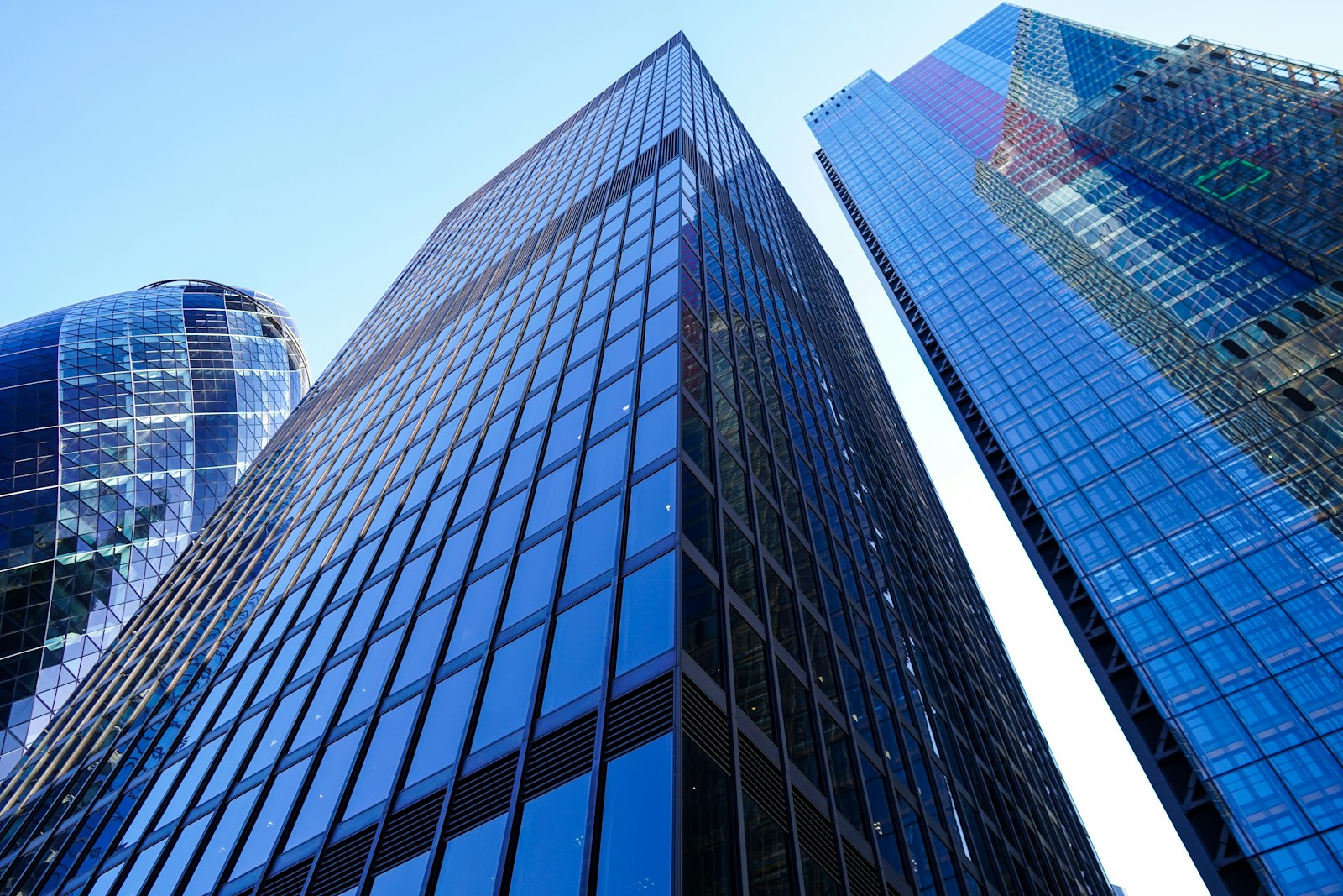 Glass buildings viewed from below, with converging architectural lines