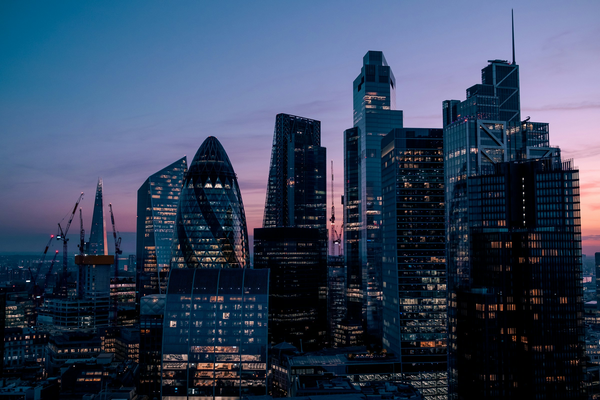 A panoramic view of buildings in a financial district at dusk